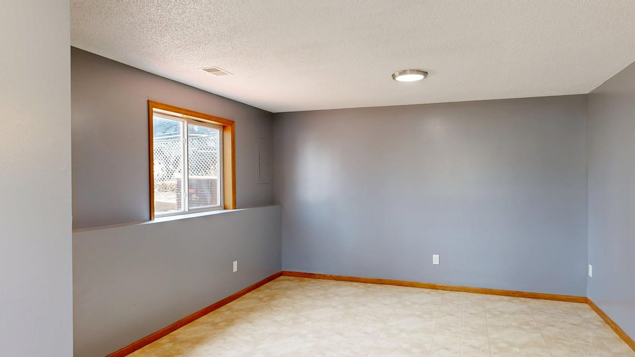 Services Bright and empty modern room with gray walls and natural light.