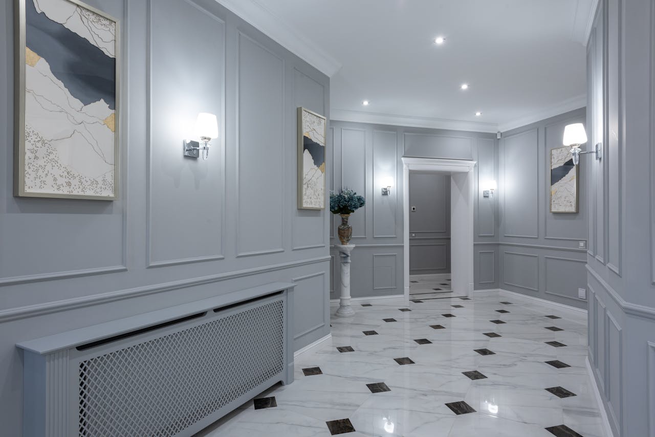 Services Interior of corridor of contemporary villa with shiny tiled floor and gray walls decorated with paintings and lamps