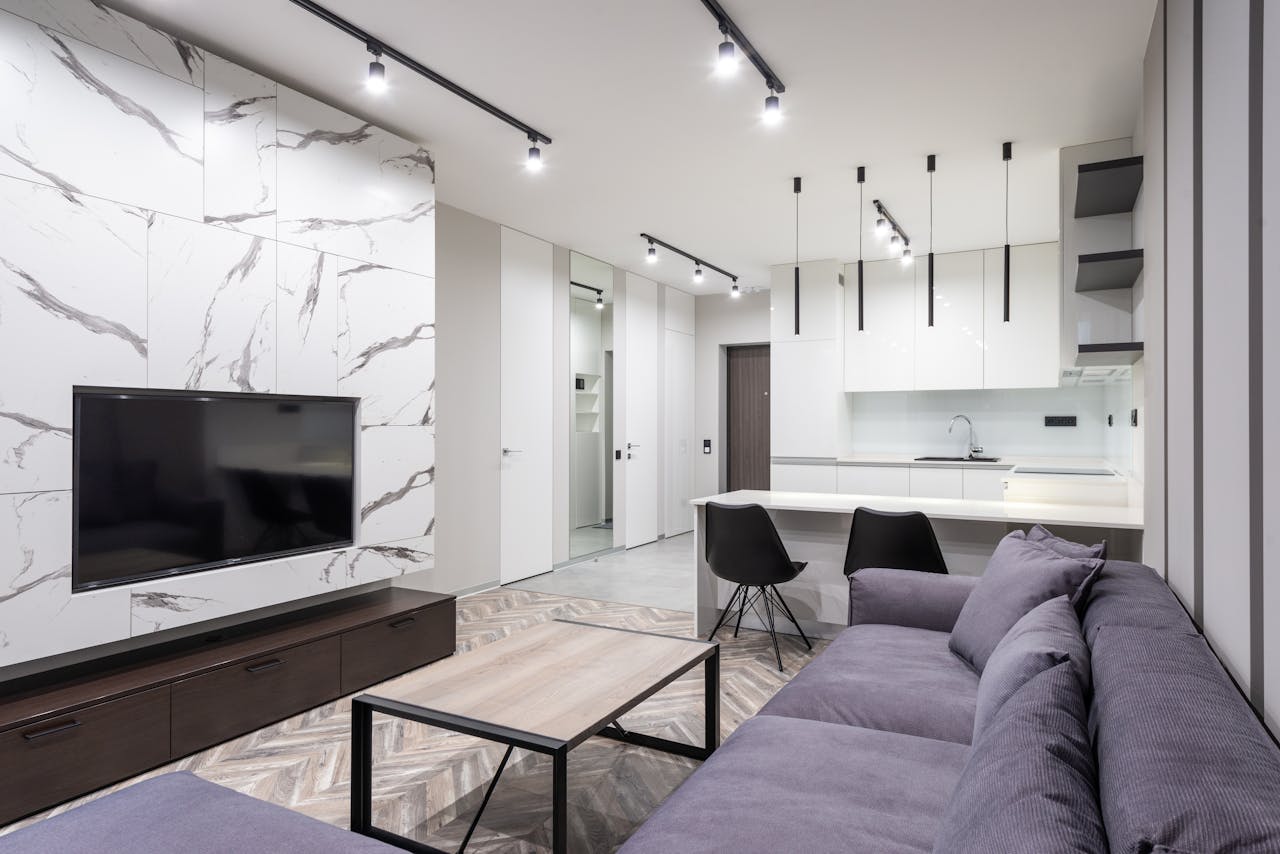 Stylish open-plan living room and kitchen with modern design elements and marble accents.